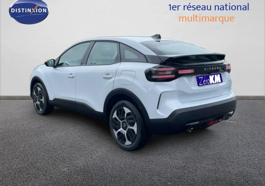 Vue 3/4 arrière droite d'une Citroën C4 blanche métal avec toit noir et jantes au design moderne.
