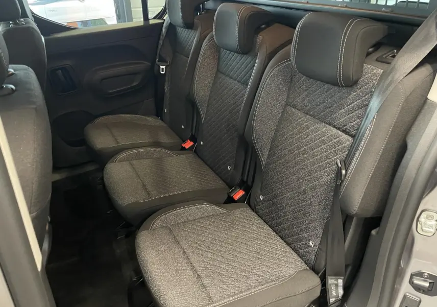Vue intérieure sur la banquette arrière tissu Sixties gris du Peugeot Rifter 2026, avec portes coulissantes ouvertes.