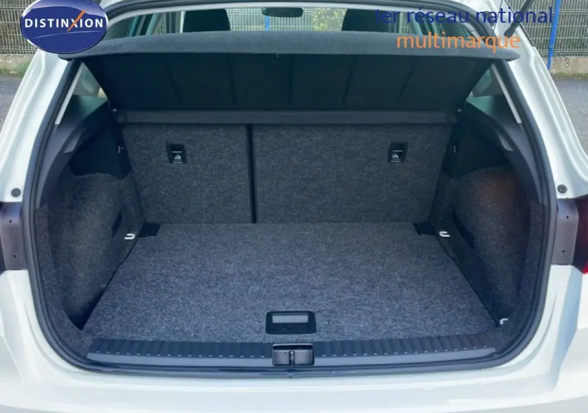 Coffre ouvert vu de l'arrière d'une SEAT Arona blanc avec toit gris, montrant l'espace de chargement vide.