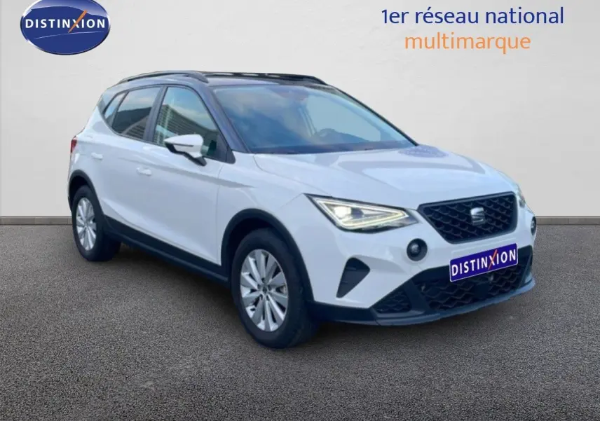 SEAT Arona blanc avec toit gris, vue 3/4 avant droit, calandre noire et feux LED allumés.