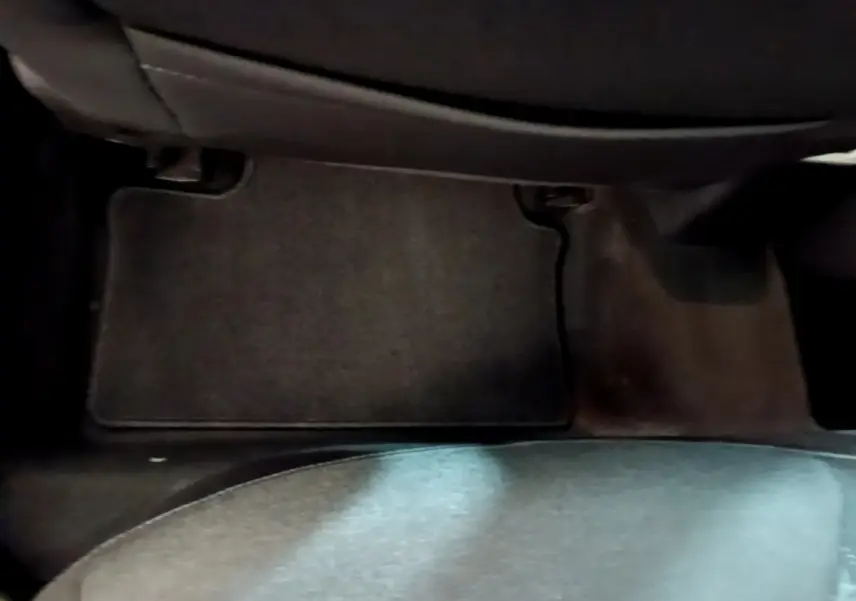 Vue rapprochée du tapis de sol noir côté passager arrière d’une Renault Clio blanche, version Business 2021.