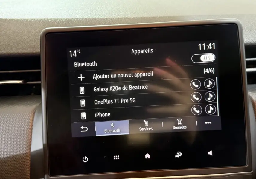 Écran tactile central de la Renault Clio Business blanc, affichant la connexion Bluetooth avec plusieurs appareils listés.