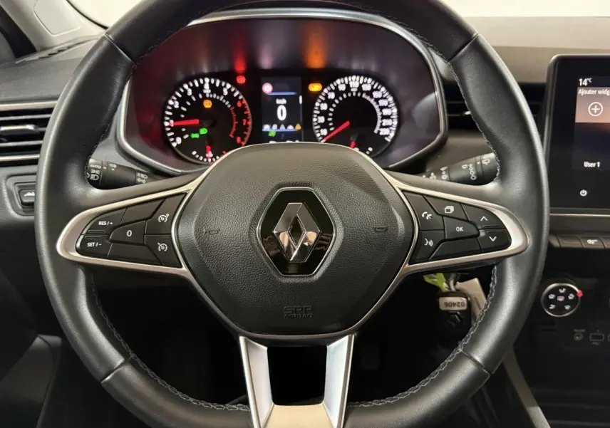 Vue rapprochée du volant cuir noir de la Renault Clio Business 2020 avec tableau de bord et commandes intégrées.