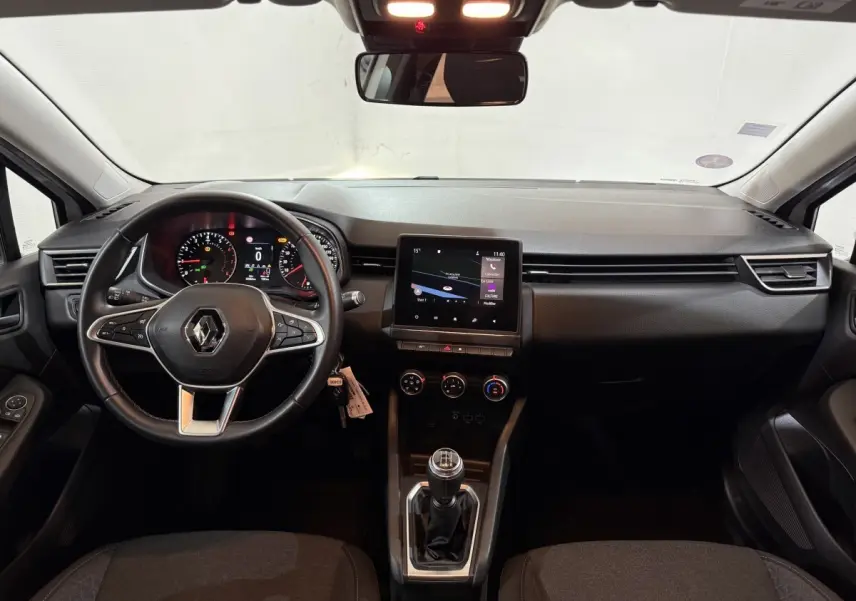 Vue intérieure avant de la Renault Clio Business avec tableau de bord noir, écran tactile central et volant multifonctions cuir.