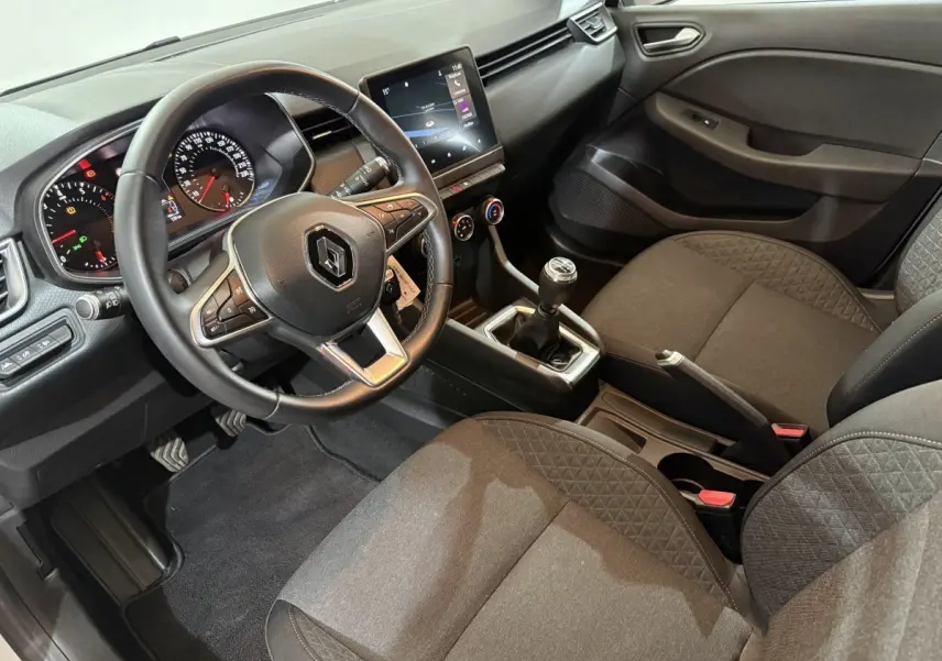 Vue intérieure côté conducteur de la Renault Clio Business 2020, volant cuir, tableau de bord avec écran tactile et boîte manuelle.