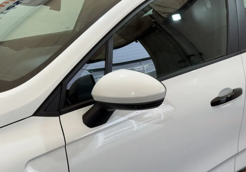 Gros plan sur le rétroviseur côté conducteur blanc et la porte avant droite blanche d’une Renault Clio Business 2020.