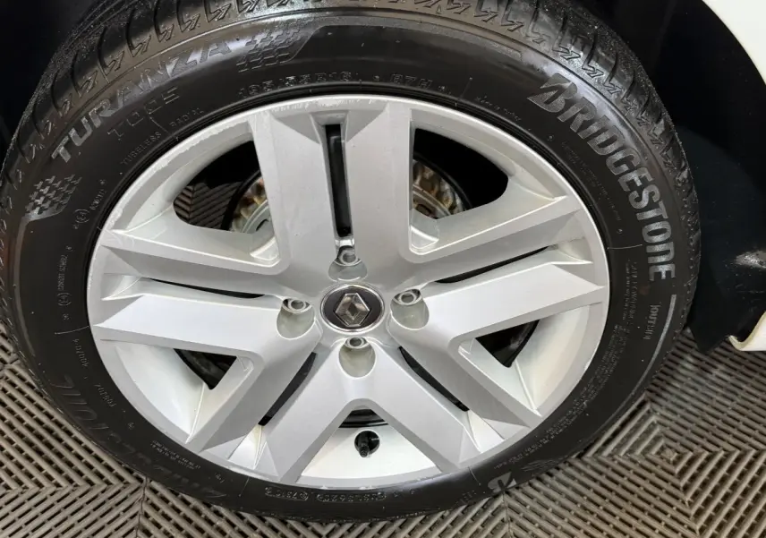 Gros plan sur la roue arrière droite d'une Renault Clio blanche de 2020 avec pneu Bridgestone visible.