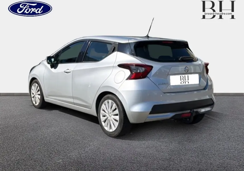 Vue 3/4 arrière droite d'une Nissan Micra argent avec becquet et attelage de remorque visible.