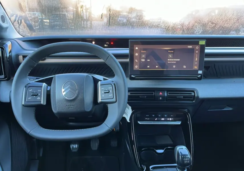 Vue intérieure centrée sur le volant cuir multifonctions et l’écran tactile 10,25 pouces du Citroën C3 Aircross 2025.