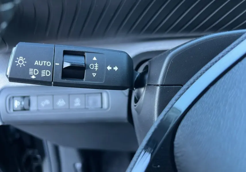 Gros plan sur la commande des feux et clignotants à gauche du volant d’un Citroën C3 Aircross noir perla nera.