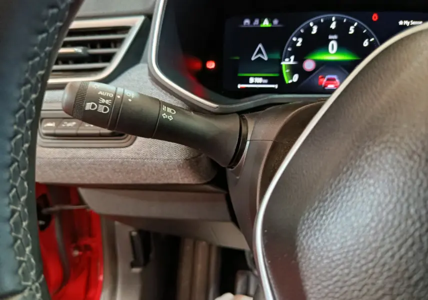 Détail du combiné d'instruments numérique et du commodo gauche du volant dans une Renault Clio Techno TCe 90 rouge 2024.