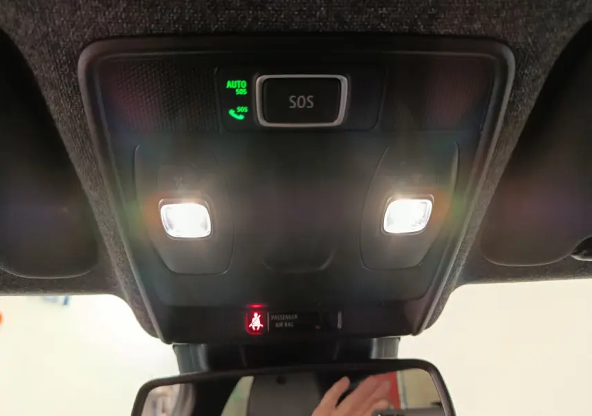 Vue intérieure du plafonnier avec éclairage et bouton SOS allumé sur Renault Clio Techno TCe 90 rouge 2024.