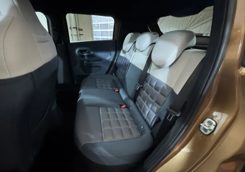 Vue intérieure côté droit sur la banquette arrière bi-ton beige et gris du Fiat Grande Panda marron 2025.