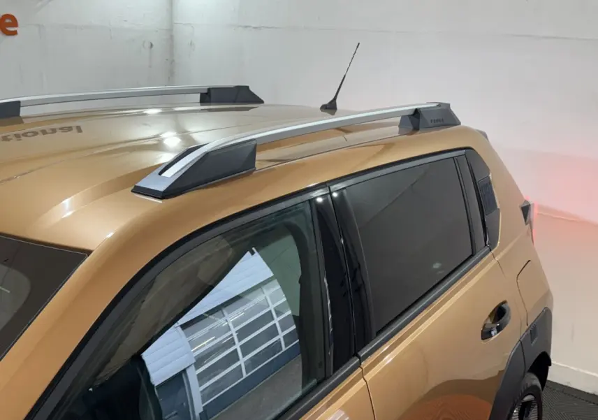 Vue de côté droit arrière sur la FIAT Grande Panda marron 2025 avec barres de toit et vitres teintées.