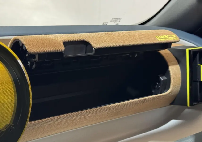 Intérieur de la FIAT Grande Panda 2025, détail de la boîte à gants ouverte avec habillage marron texturé Bambox.