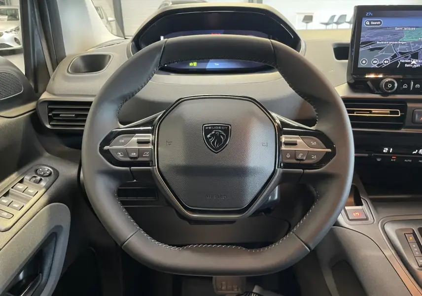Vue rapprochée du volant cuir multifonction noir du Peugeot Rifter 2026 avec tableau de bord numérique et écran tactile.