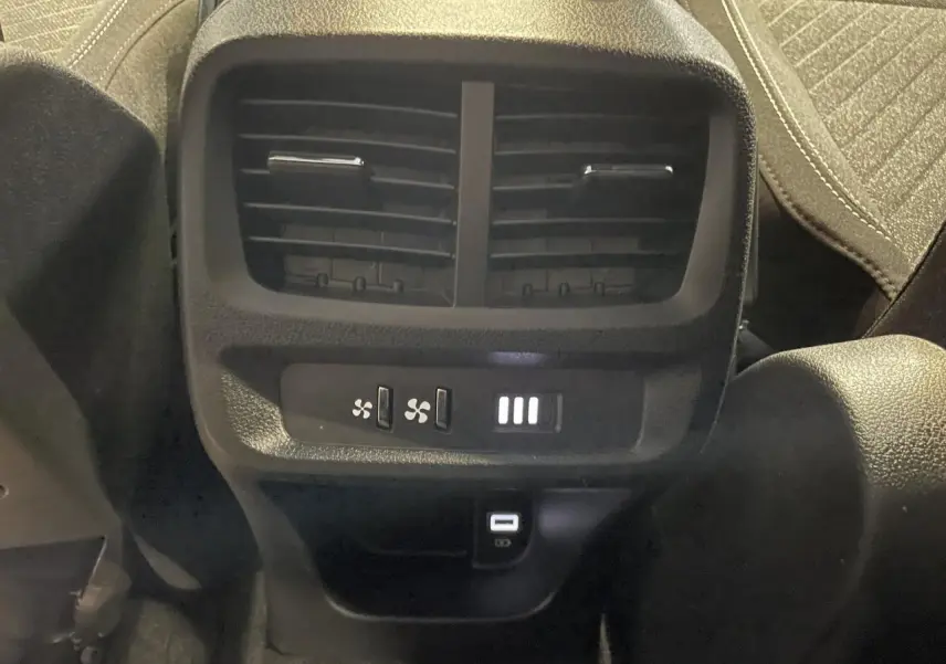 Vue rapprochée des aérateurs arrière et des ports USB Type-C du Peugeot Rifter gris Artense, version 2026.