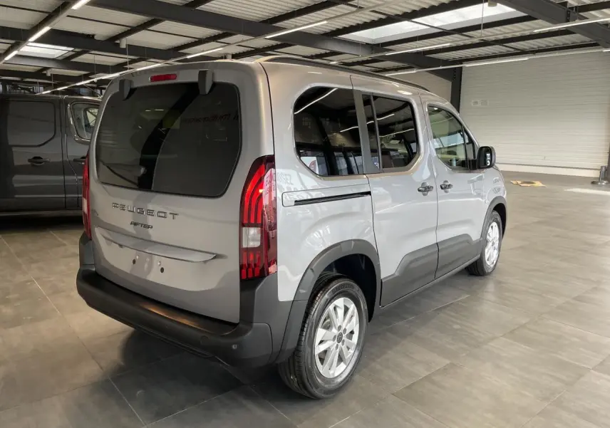 Vue 3/4 arrière droit du Peugeot Rifter gris Artense avec feux arrière verticaux et jantes tôles 16 pouces en showroom.