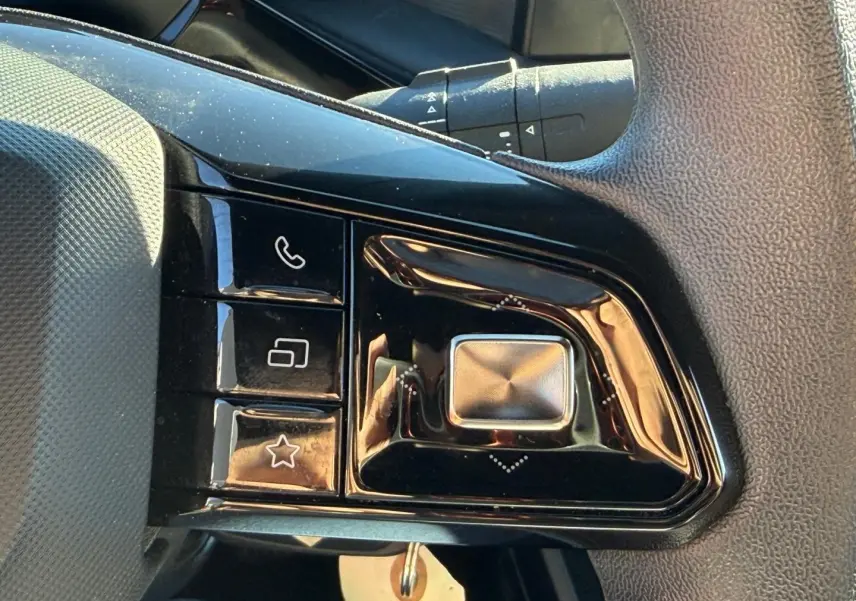Gros plan sur les commandes multifonctions noires du volant côté gauche du MG3 Pebble Black 2024.