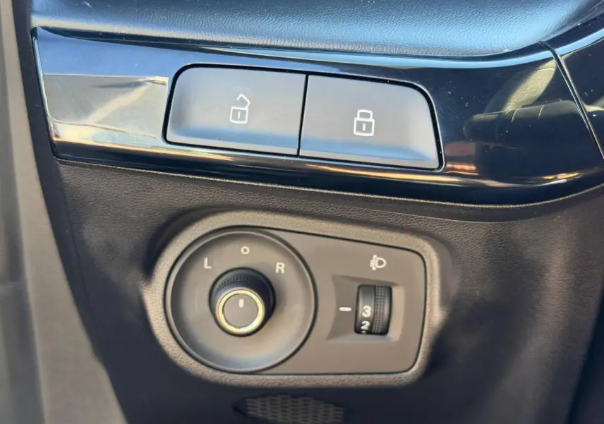 Gros plan sur les commandes de réglage des rétroviseurs et verrouillage, intérieur noir du MG3 2024 Pebble Black.