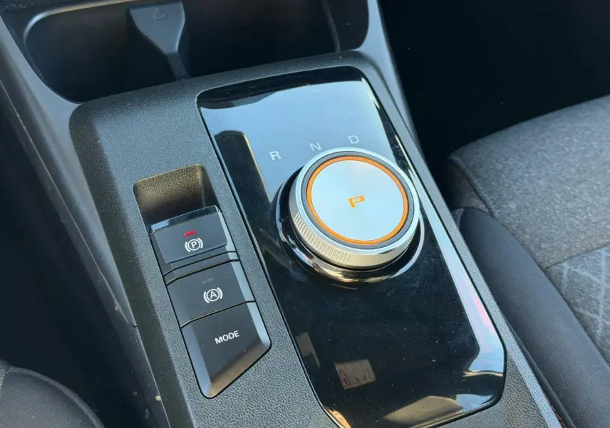 Gros plan sur la molette de boîte automatique et les boutons de commande, intérieur noir du MG3 1.5 Hybrid+ 2024.