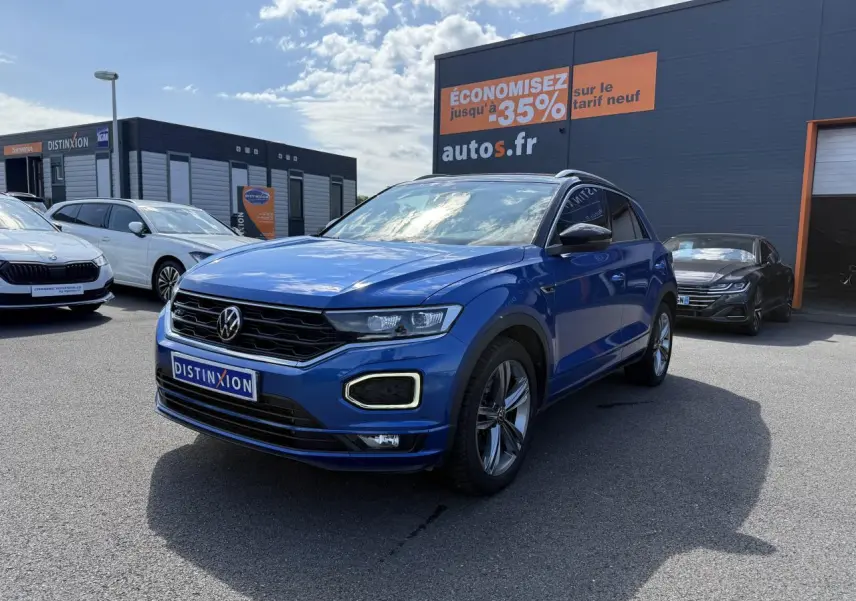 Volkswagen T-Roc bleu Ravenna métallisé en 3/4 avant droit avec jantes alliage et calandre noire distinctive.
