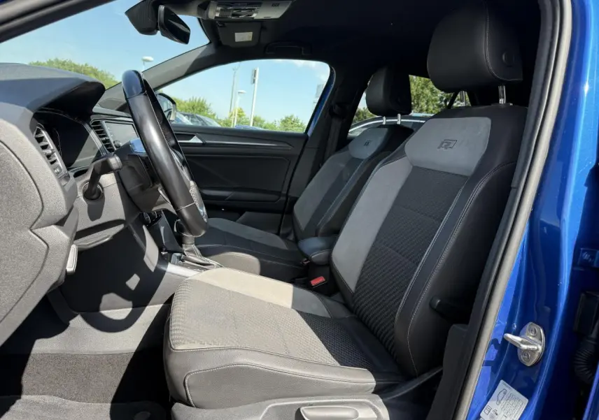 Intérieur avant du Volkswagen T-Roc bleu Ravenna, sièges sport R-Line en cuir et alcantara gris et noir.