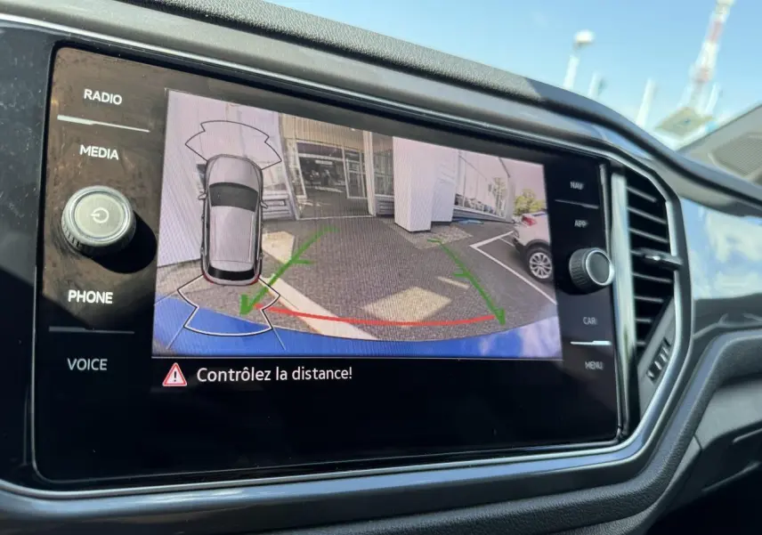 Écran de caméra de recul du Volkswagen T-Roc bleu Ravenna, vue arrière avec guidage de trajectoire verte et rouge.