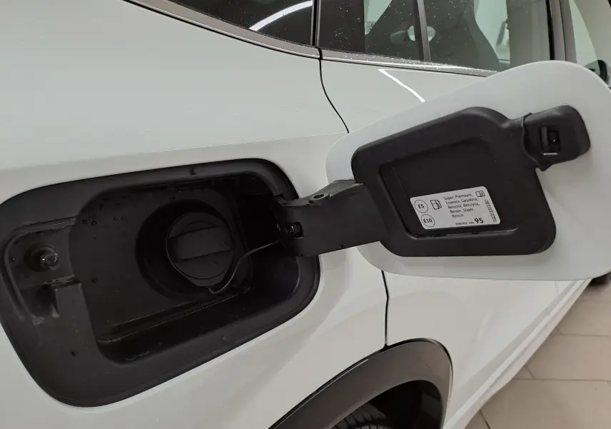 Gros plan sur la trappe à carburant côté gauche d’un Volkswagen Tiguan blanc pur 2025 essence.