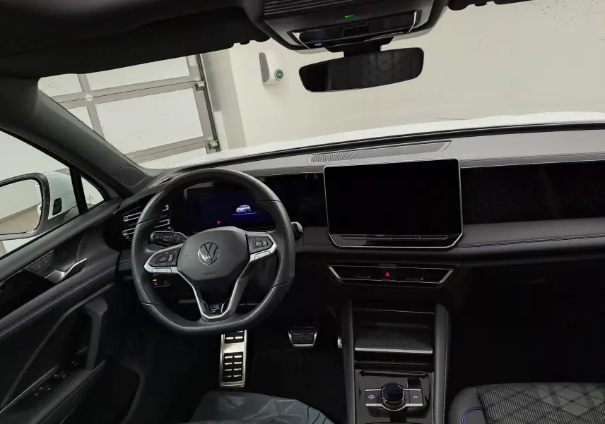 Vue intérieure du tableau de bord et volant noir du Volkswagen Tiguan 1.5 eTSI R-Line Edition 2025, avec écran tactile central.