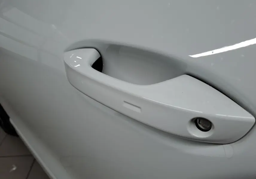 Poignée de porte blanche vue de près sur le côté gauche d'un Volkswagen Tiguan 2025 finition R-Line.