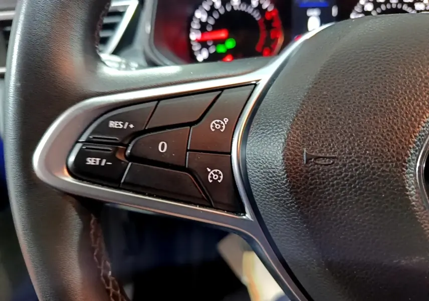 Gros plan sur le volant cuir synthétique noir de la Renault Clio Business 2022, avec commandes multifonctions visibles.