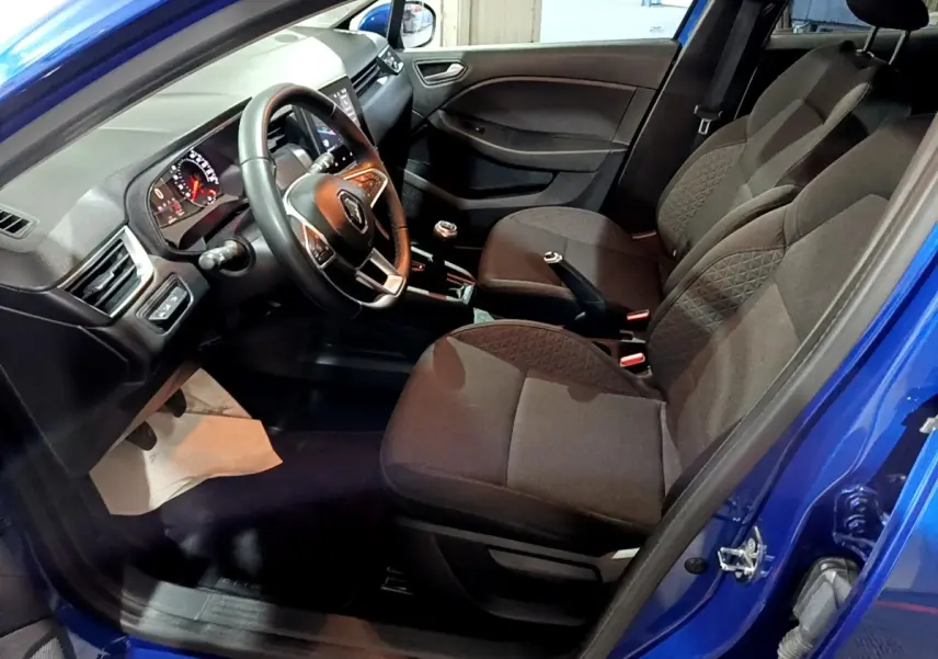 Vue intérieure côté conducteur de la Renault Clio Business bleu 2022, volant cuir multifonctions et sièges tissu gris.
