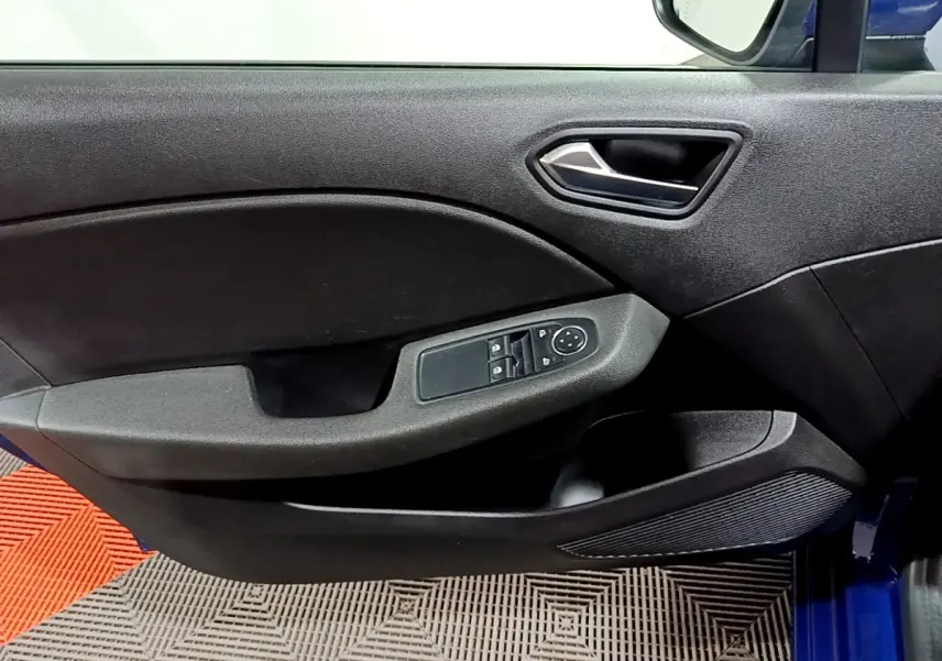 Vue rapprochée de la porte avant gauche noire de la Renault Clio Business bleu, avec commandes électriques et poignée argentée.