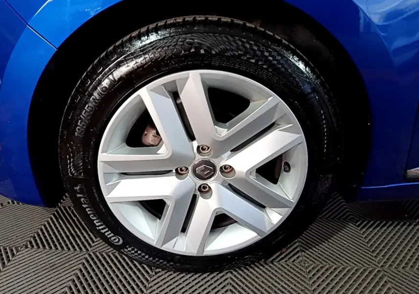 Gros plan sur la roue avant gauche avec jante alliage argentée et carrosserie bleu vif d'une Renault Clio Business 2022.