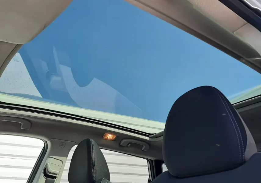 Vue intérieure du Nissan Qashqai 1.2 DIG-T 2018 montrant le toit panoramique et les sièges avant en tissu noir.