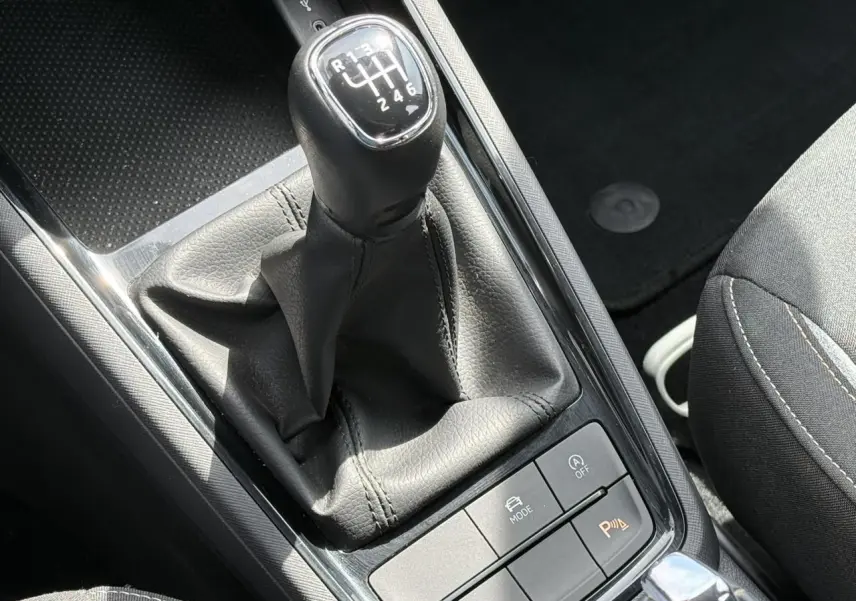 Le levier de vitesse manuel noir de la Skoda Scala TSI 116, avec console centrale et siège partiel gris.