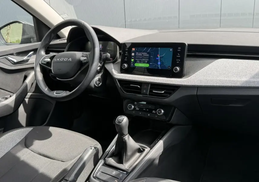 Vue intérieure côté conducteur de la Skoda Scala TSI 116 gris graphite, volant cuir et écran tactile 8,25 pouces.