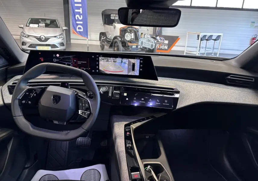 Intérieur du Peugeot 3008 hybride 2026, vue du poste de conduite avec volant compact et écran incurvé panoramique.