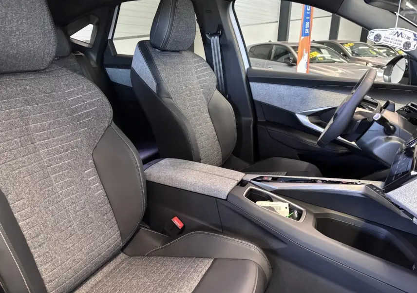 Vue intérieure côté droit du Peugeot 3008 2026, montrant les sièges tissu gris et cuir noir avec console centrale assortie.