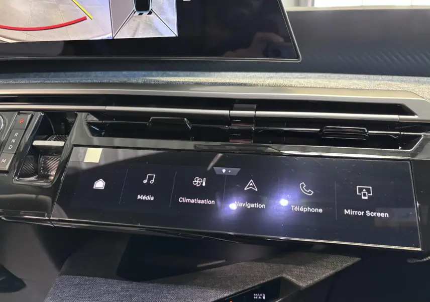 Vue rapprochée de la console centrale tactile noire du Peugeot 3008 blanc, affichant les commandes multimédia et climatisation.