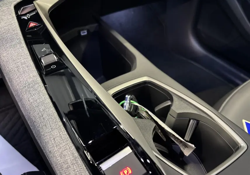 Détail de la console centrale noire et grise avec commande frein à main électrique du Peugeot 3008 hybride blanc.