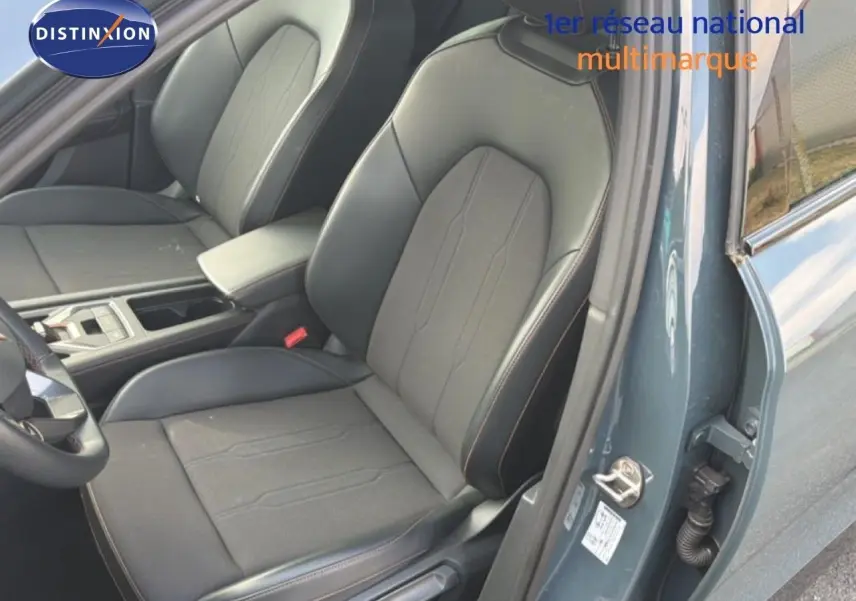 Vue intérieure côté conducteur du CUPRA Formentor gris magnétique, mettant en valeur les sièges en tissu et cuir noir avec surpiqûres.