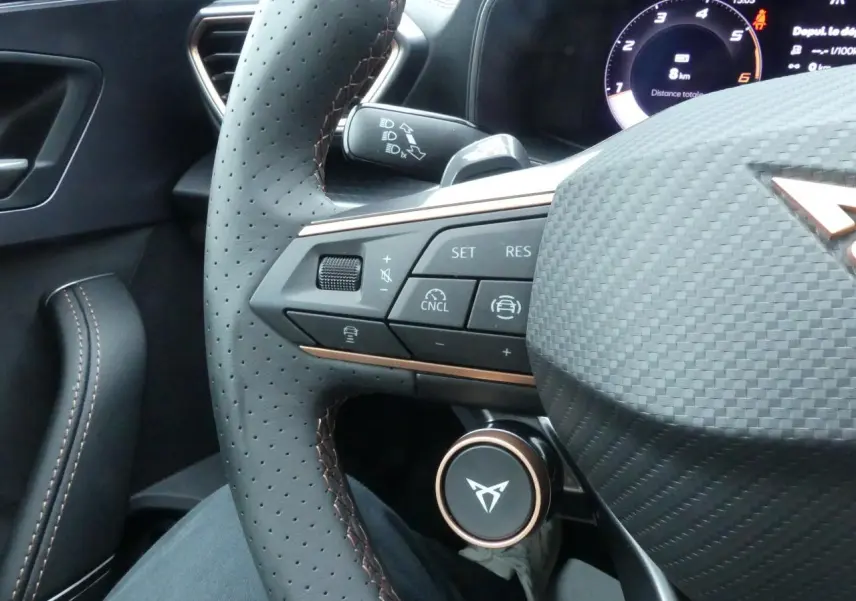 Gros plan sur le volant perforé noir avec surpiqûres cuivrées et commandes multifonctions du CUPRA Formentor 2025.