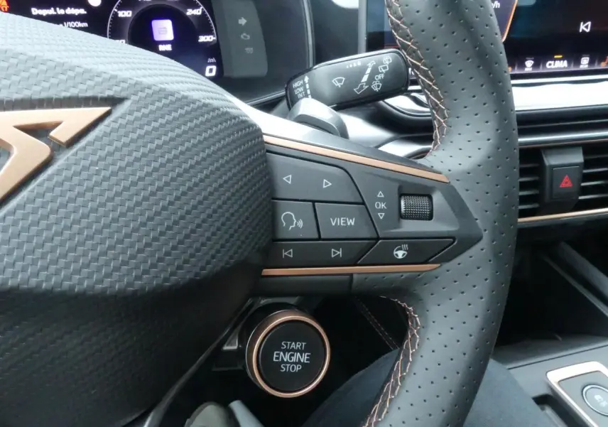 Gros plan sur le volant perforé noir avec surpiqûres cuivrées et bouton Start Engine Stop du CUPRA Formentor 2025.