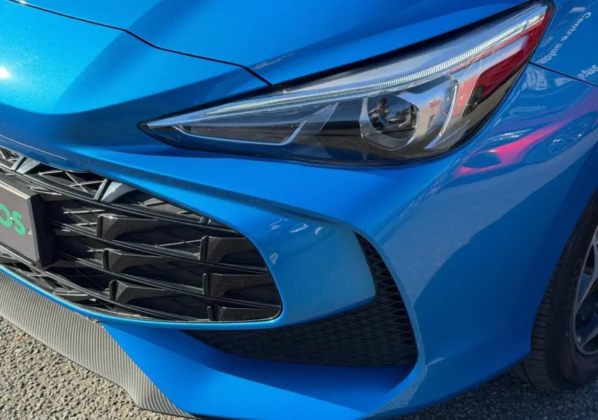 Gros plan sur l'avant droit bleu Como métallisé du MG3 1.5 Hybrid+ 195ch avec optique et calandre distinctifs.