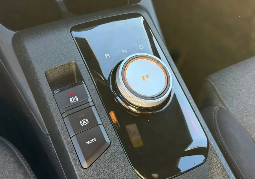 Gros plan sur la molette de boîte automatique noire avec indication "P" orange dans l’habitacle du MG3 2024.