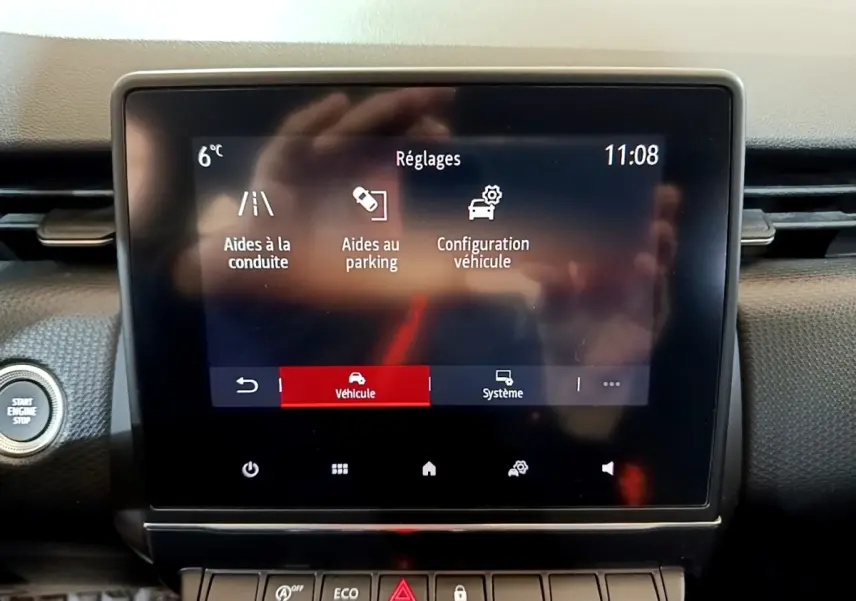 Écran tactile central de la Renault Clio Business TCe 100 2020 affichant les réglages d’aides à la conduite et au parking.