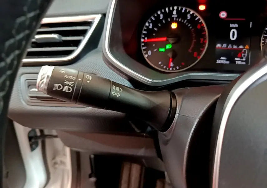 Gros plan sur la commande des phares et clignotants à gauche du volant dans une Renault Clio Business blanche de 2020.