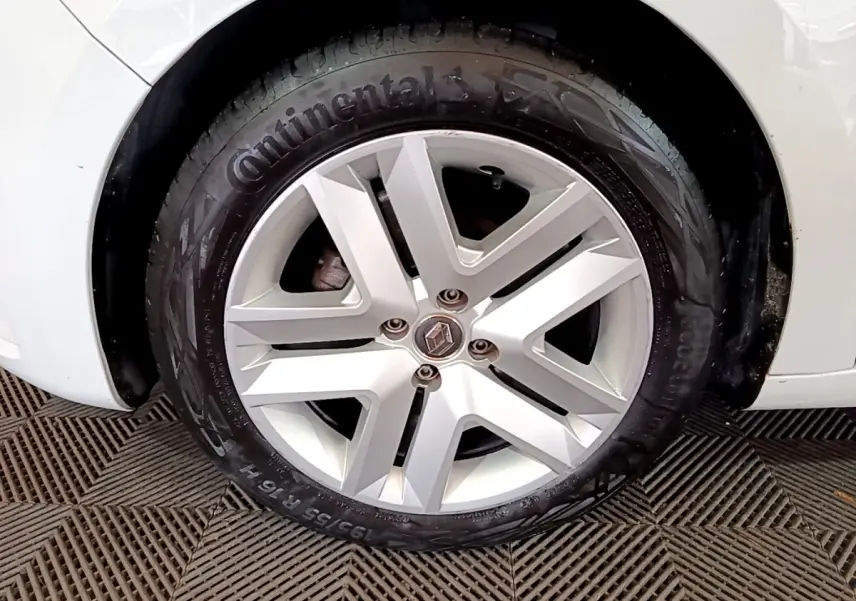 Gros plan sur la roue avant droite blanche d'une Renault Clio Business TCe 100 avec jante alliage et pneu Continental.